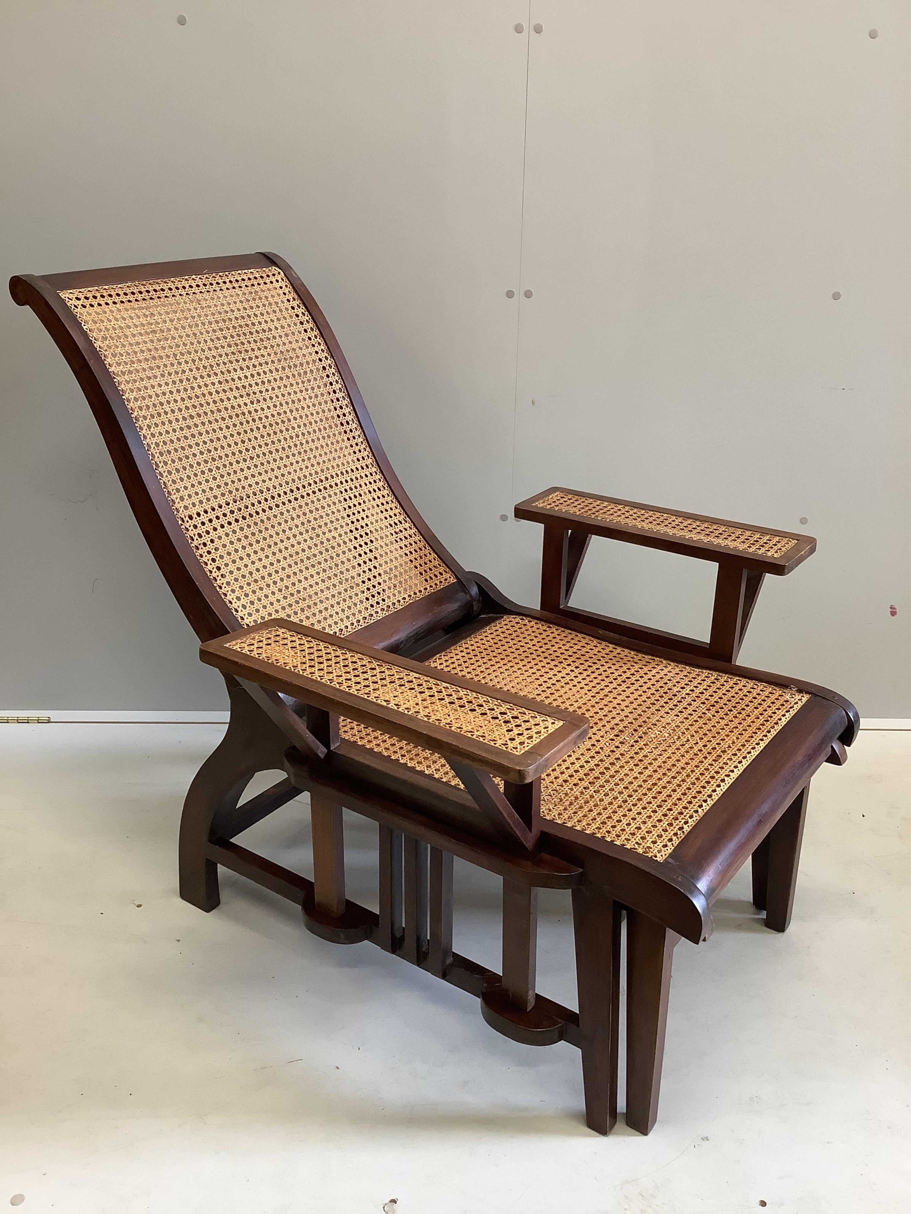 A pair of mid 20th century caned hardwood reclining garden chairs with integral sliding footrests and detachable armrests, width 85cm, depth 90cm, height 106cm. Condition - good